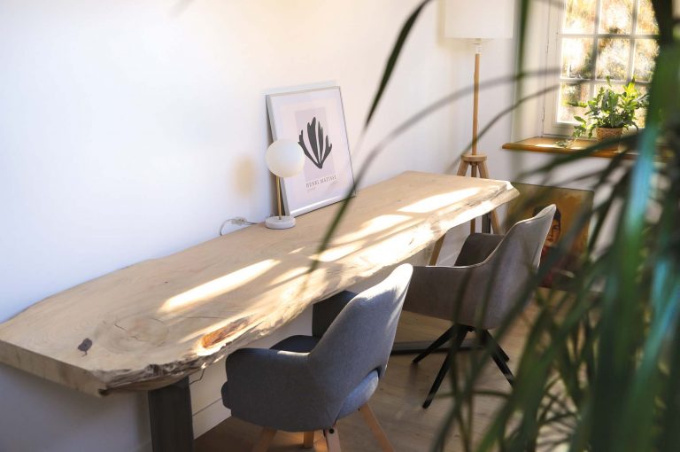 Un bureau en planche de bois massif qui baigne dans la lumière du jardin