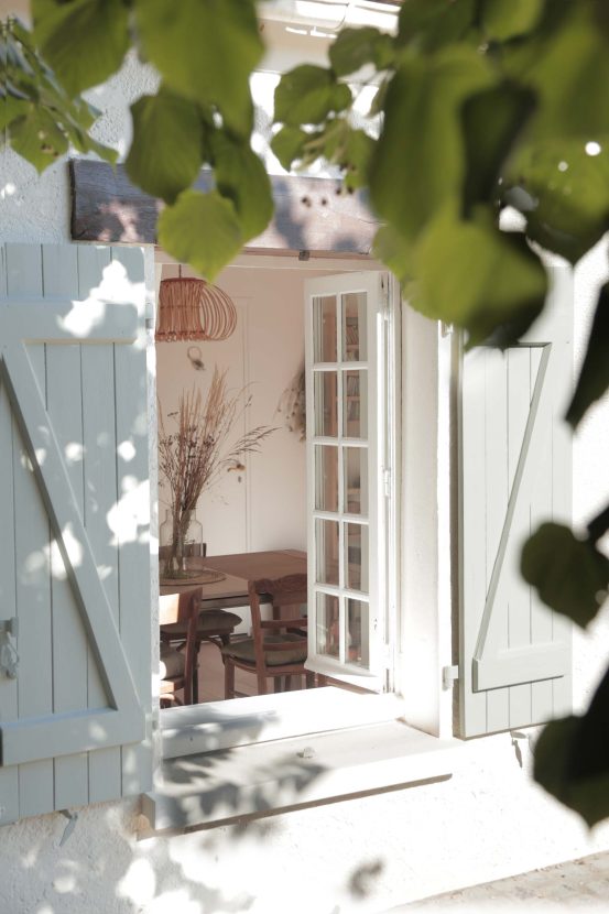 Une fenêtre de l'extérieur qui donne sur l'intérieur de la maison de campagne du coworking À la fraîche